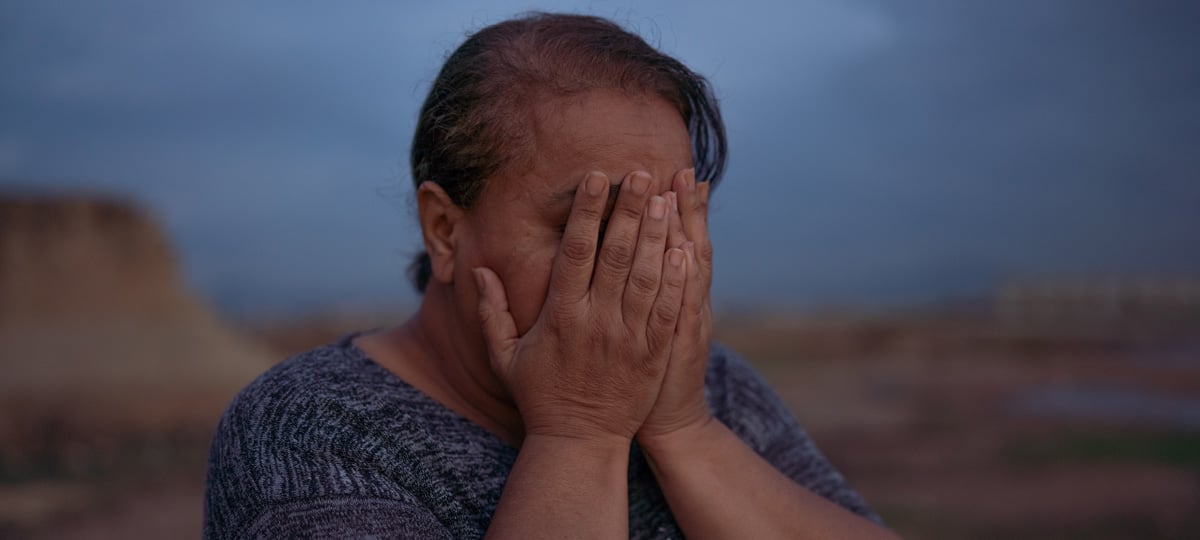 Vrouw verbergt haar gezicht achter haar handen