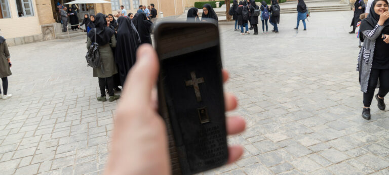 Kruis van een kathedraal reflecteert op een smartphone