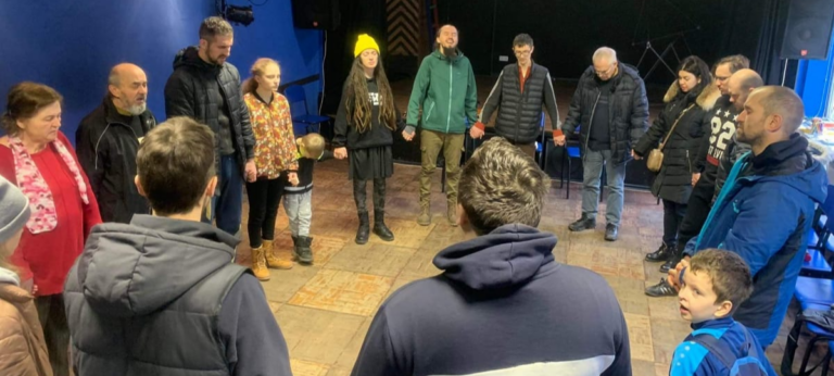 Mannen en vrouwen hand in hand met elkaar in gebed
