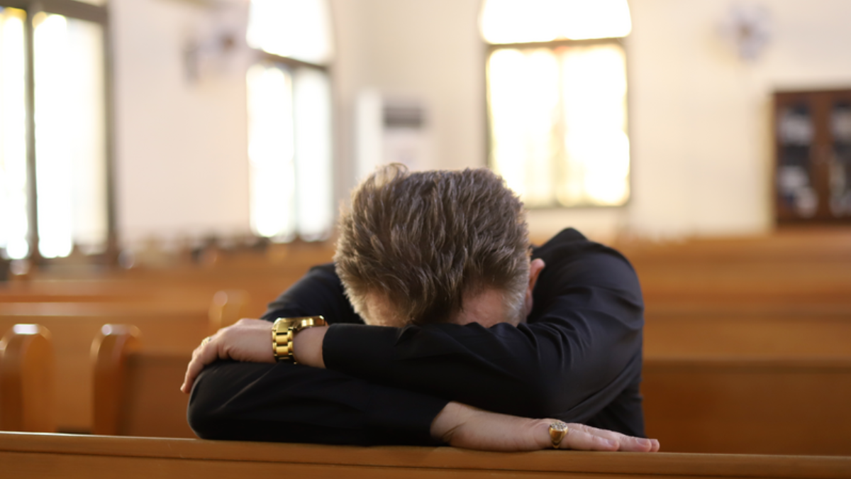 Man bedekt zijn gezicht in de kerk