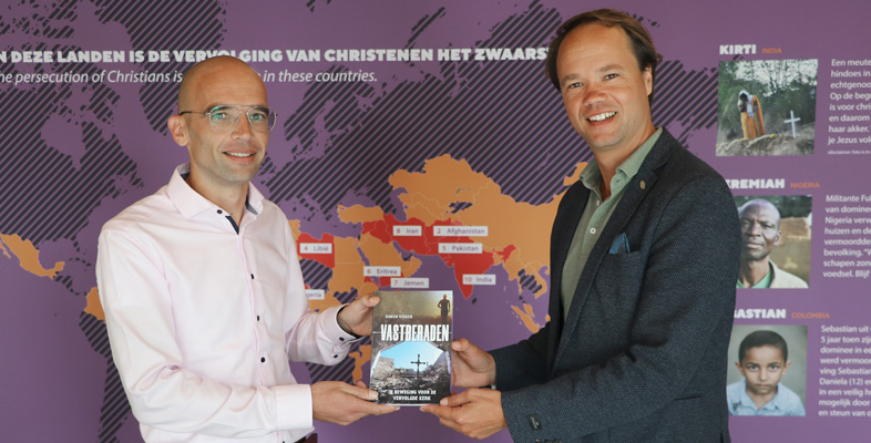 Simon Visser overhandigt het boek Vastberaden aan Henk Stoorvogel