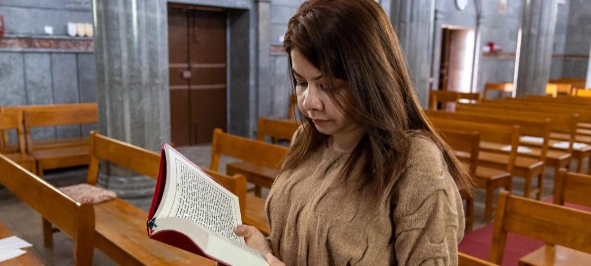 Vrouw leest Bijbel in kerk