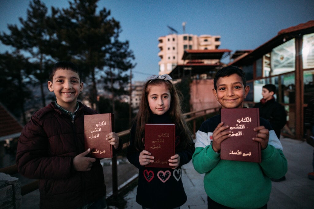 Drie kinderen met Bijbels in Mashta Al Helou Syrië