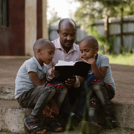 Ermias leest het kerstverhaal voor aan zijn kinderen