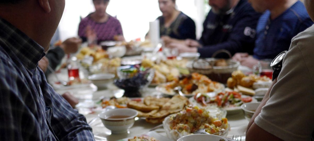 Mensen uit Centraal-Azië aan tafel met eten